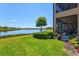Landscaped backyard with a lake view and access to a screened lanai from the main floor at 23528 Awabuki Dr # 101, Venice, FL 34293