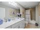 Bathroom featuring a double sink vanity with marble countertop and a shower with neutral tile at 23528 Awabuki Dr # 101, Venice, FL 34293