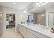 Bathroom featuring double sinks, granite countertops, walk-in shower, and walk-in closet at 23528 Awabuki Dr # 101, Venice, FL 34293