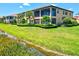 Beautiful exterior view of a two-story home with a well-maintained lawn and water feature at 23528 Awabuki Dr # 101, Venice, FL 34293