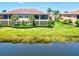 Scenic exterior of a two-story home featuring a screened-in patio and lush landscaping near a pond at 23528 Awabuki Dr # 101, Venice, FL 34293