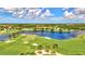 Scenic aerial shot of the Sarasota National golf course, showcasing the lush green fairway and sparkling blue lake at 23528 Awabuki Dr # 101, Venice, FL 34293