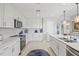 A kitchen with stainless steel appliances, white cabinetry, granite countertops, and tile backsplash at 23528 Awabuki Dr # 101, Venice, FL 34293