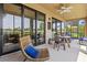 Enjoy the outdoor living space with this spacious lanai featuring a ceiling fan, dining and rocking chairs at 23528 Awabuki Dr # 101, Venice, FL 34293