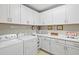 Bright laundry room with white cabinetry, a washer and dryer, and counter space for folding clothes at 23528 Awabuki Dr # 101, Venice, FL 34293