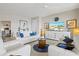 Elegant living room with a ceiling fan, white sofas, and an entertainment center at 23528 Awabuki Dr # 101, Venice, FL 34293