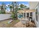 Inviting backyard featuring a patio with a grill, dining table, and lush landscaping with a game of cornhole nearby at 2646 Martin St, Sarasota, FL 34237