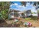 Expansive backyard featuring a white privacy fence, lush green lawn, outdoor seating, and a charming home exterior at 2646 Martin St, Sarasota, FL 34237