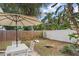 Inviting backyard features a white fence, tropical landscaping, and games at 2646 Martin St, Sarasota, FL 34237