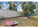 Spacious backyard with a white fence, lush tropical plants, and fun with the cornhole boards and bean bags at 2646 Martin St, Sarasota, FL 34237