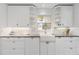 Well-lit kitchen with white cabinets, granite countertops, and modern fixtures at 2646 Martin St, Sarasota, FL 34237