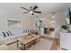 Bright living room with white sofa, ceiling fan, and view to dining area at 2646 Martin St, Sarasota, FL 34237
