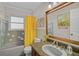 Bathroom featuring yellow tiled walls, bath/shower combo, and a vanity with sink at 2708 27Th Avenue W Dr, Bradenton, FL 34205
