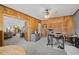 Bonus room with wood paneling, ceiling fan, view to the living room, and drum set at 2708 27Th Avenue W Dr, Bradenton, FL 34205