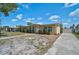 Side view of a single story home with landscaped yard and a long driveway, complemented by a sunny sky at 2708 27Th Avenue W Dr, Bradenton, FL 34205