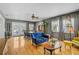 Bright living room with wood floors, blue couch, dining table, and large windows with curtains at 2708 27Th Avenue W Dr, Bradenton, FL 34205