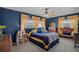 Main bedroom with blue walls, three windows, wood trim, and ceiling fan at 2708 27Th Avenue W Dr, Bradenton, FL 34205