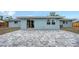 View of a grey brick paver patio and sliding glass doors that lead into the home at 2825 Pinecrest St, Sarasota, FL 34239