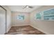A clean bedroom features two windows and hardwood floors and a ceiling fan at 2825 Pinecrest St, Sarasota, FL 34239