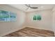 This bedroom features neutral walls and hardwood floors, two windows and a ceiling fan at 2825 Pinecrest St, Sarasota, FL 34239