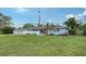 Charming single-story blue home with a white fence, lush green lawn, and welcoming curb appeal at 2825 Pinecrest St, Sarasota, FL 34239