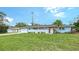 Beautifully landscaped blue home featuring a well-manicured lawn and attached two car garage at 2825 Pinecrest St, Sarasota, FL 34239