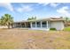 Exterior view of the house featuring a screened patio with access to the spacious, dry backyard at 3432 Pine Valley Dr, Sarasota, FL 34239