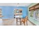 A dining area with tile floors and glass table, with a window and access to the screened lanai at 3432 Pine Valley Dr, Sarasota, FL 34239