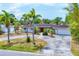 Inviting single-story home featuring a pergola, red tile roof, mature landscaping, and circular driveway at 3432 Pine Valley Dr, Sarasota, FL 34239