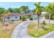 Charming single-story home with a red tile roof, circular driveway, and mature palm trees at 3432 Pine Valley Dr, Sarasota, FL 34239