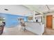 Open-concept living space with bar, tile flooring, and sliding glass doors to backyard at 3432 Pine Valley Dr, Sarasota, FL 34239