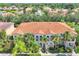 An aerial view of a residential building with a red tile roof and lush green landscaping at 3760 82Nd Avenue E Cir # 102, Sarasota, FL 34243