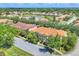 Beautiful aerial view of townhouses, lush landscaping, and a tranquil pond in a well-maintained community at 3760 82Nd Avenue E Cir # 102, Sarasota, FL 34243