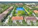 Gorgeous aerial view of townhouses surrounding a large pond with mature landscaping and manicured lawns at 3760 82Nd Avenue E Cir # 102, Sarasota, FL 34243