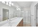 Bathroom featuring dual sinks, a large mirror and a glass enclosed walk-in shower at 3760 82Nd Avenue E Cir # 102, Sarasota, FL 34243