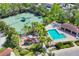 Aerial view of a community with tennis courts, playground, and inviting blue pool surrounded by lush landscaping at 3760 82Nd Avenue E Cir # 102, Sarasota, FL 34243