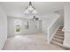 Open concept living area with chandelier, ceiling fan, staircase and exterior door to the backyard at 3760 82Nd Avenue E Cir # 102, Sarasota, FL 34243