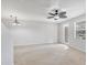 Large living room with light carpet, ceiling fan, light fixture, and exterior door at 3760 82Nd Avenue E Cir # 102, Sarasota, FL 34243