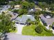 Stunning aerial view of a home with lush landscaping, a circular driveway, and a well-manicured lawn at 3905 Country View Dr, Sarasota, FL 34233