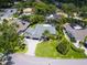 Aerial view of landscaped property with circular driveway, mature trees, and swimming pools in a quiet neighborhood at 3905 Country View Dr, Sarasota, FL 34233
