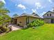 Exterior view of the home's backyard featuring a well-manicured lawn, landscaping, and a covered patio at 3905 Country View Dr, Sarasota, FL 34233