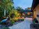 Landscaped backyard with pond, tropical plants, stone walkway, and screened-in pool area at 3905 Country View Dr, Sarasota, FL 34233