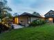 Exterior shot of home at dusk, highlighting backyard, water feature and lush landscaping at 3905 Country View Dr, Sarasota, FL 34233