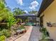 Backyard with tropical plants, stone walkway, screened pool and pond with water feature at 3905 Country View Dr, Sarasota, FL 34233
