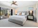 Bright bedroom features a comfortable bed, ceiling fan, and sliding glass doors to the outdoor pool area at 3905 Country View Dr, Sarasota, FL 34233
