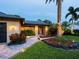 Home featuring a brick-paved walkway, glass front door, exterior lighting and meticulously kept landscaping at 3905 Country View Dr, Sarasota, FL 34233