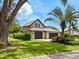 Home featuring a well-maintained lawn, mature trees, a paved driveway and a two-car garage at 3905 Country View Dr, Sarasota, FL 34233