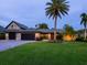Charming home with lush landscaping, featuring a paved driveway and a well-manicured lawn with mature palm trees at 3905 Country View Dr, Sarasota, FL 34233