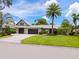 Beautiful home featuring a well-maintained lawn, brick driveway, mature palm trees, and a two-car garage at 3905 Country View Dr, Sarasota, FL 34233
