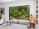 The large sliding glass doors of this living room offer views of the backyard's lush and calming waterfall at 3905 Country View Dr, Sarasota, FL 34233